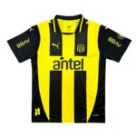 Imagem da nova Camisa titular do Peñarol 2025 com listras verticais aurinegras, gola polo preta com friso amarelo e escudo oficial do clube uruguaio.