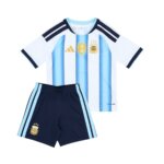 Kit Infantil Argentina I 26/27 com camisa azul e branca e patch de campeão mundial